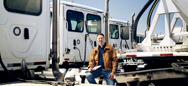 Man sits in front of trucks